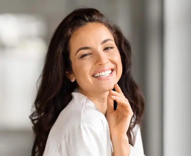 Smiling woman with bright white teeth in professional dental practice portrait.