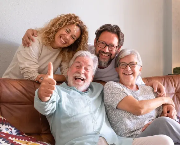 Happy multi-generational family smiling together on couch, representing quality dental care in Monterey Park.
