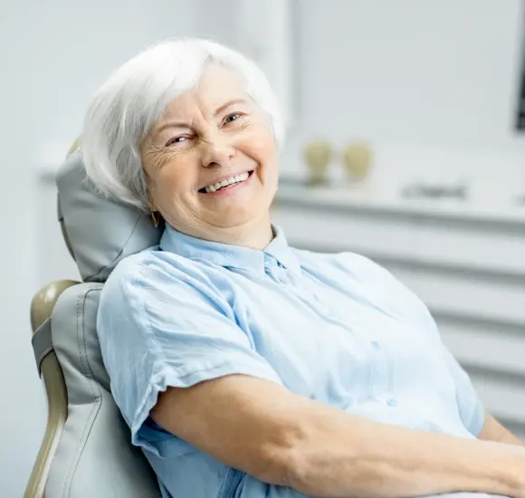 Senior woman smiling in dental chair after root canal therapy treatment in Monterey Park.