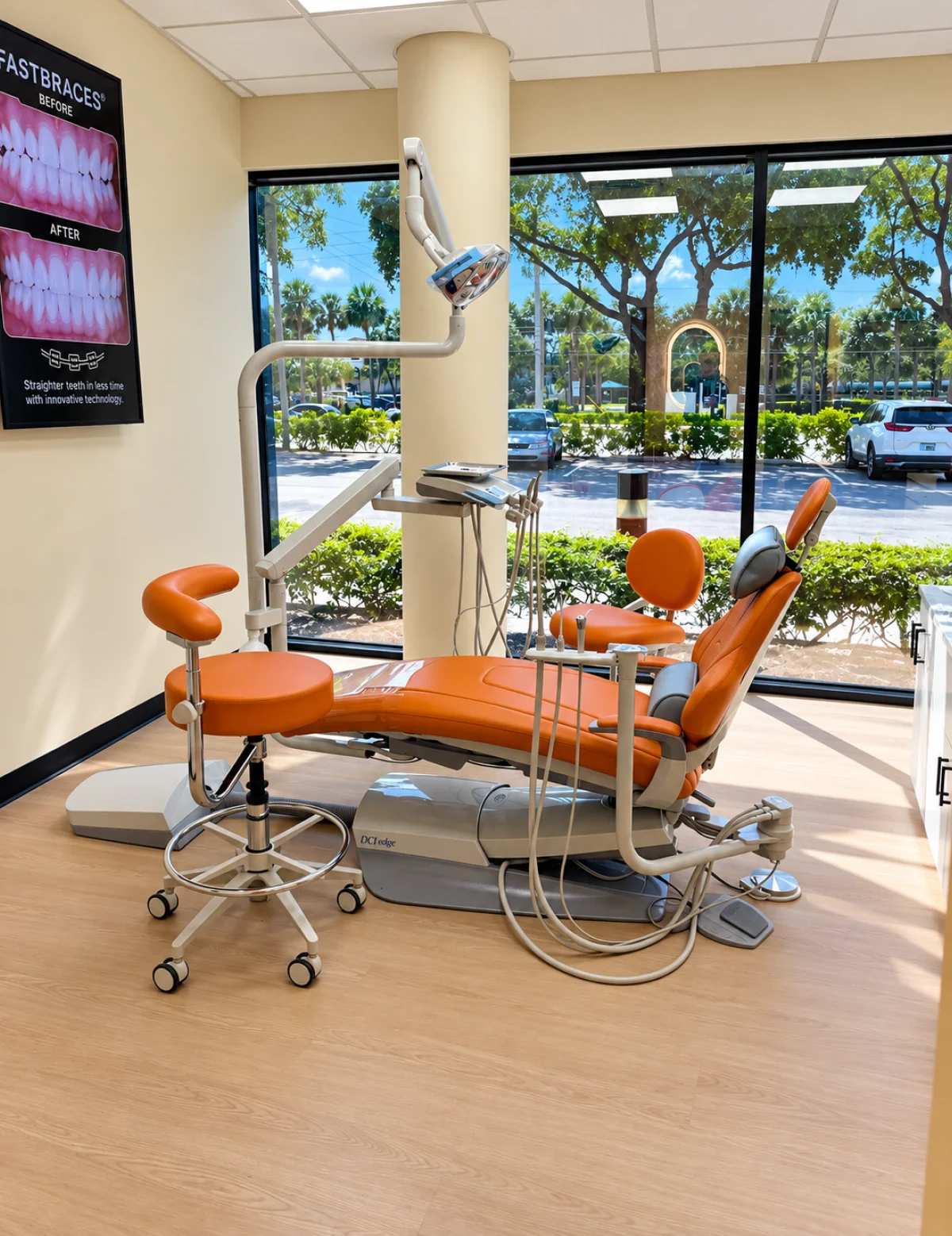 Modern treatment room with orange dental chair and garden view